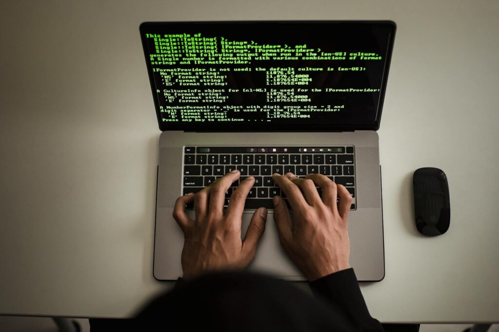 From above crop anonymous male programmer in black hoodie working on software code on contemporar... (Photo by Sora Shimazaki on Pexels)