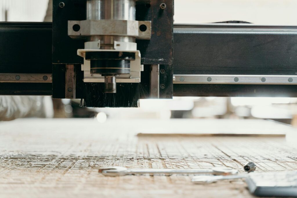 Close-up of a CNC machine carving a wooden surface indoors, showcasing precision equipment. (Photo by cottonbro studio on Pexels)