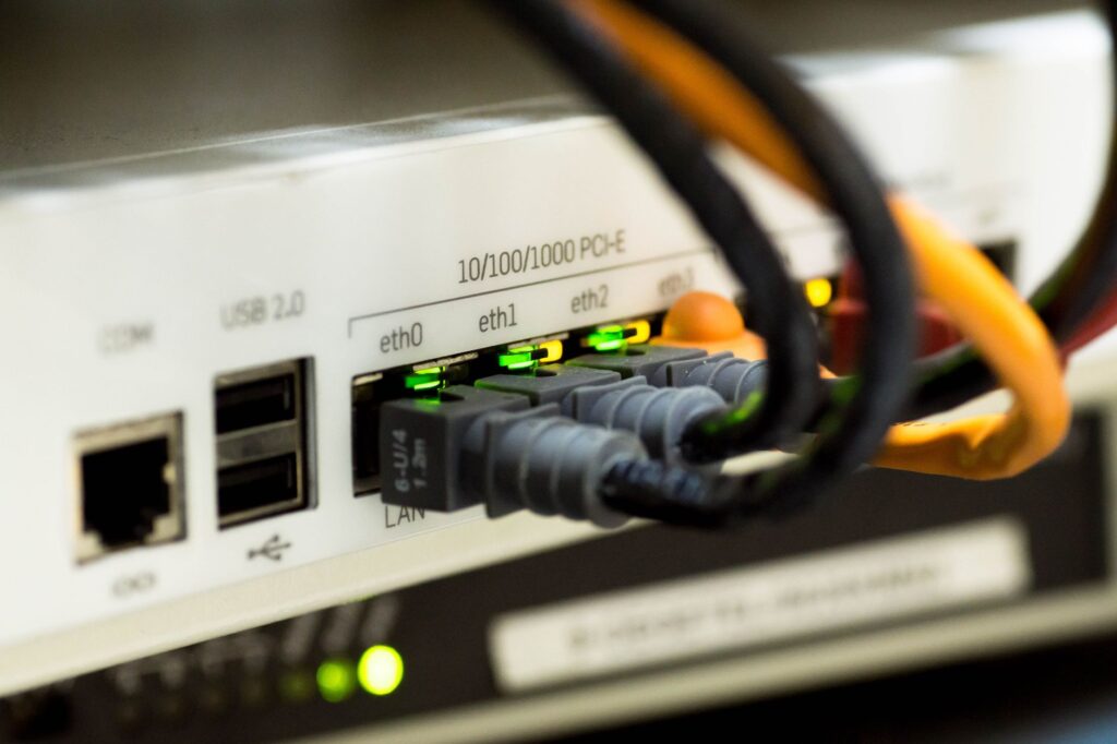 Detailed close-up of ethernet cables and network connections on a router, showcasing modern techn... (Photo by Pixabay on Pexels)